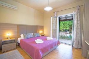 ein Schlafzimmer mit einem Bett mit einer rosa Tagesdecke in der Unterkunft Villa Marias Beach House by Villa Plus in Ágios Stéfanos + 9 Fotos