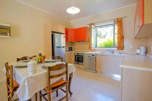 eine Küche mit einem Tisch und Stühlen sowie einem Tisch und eine Küche mit in der Unterkunft Villa Marias Beach House by Villa Plus in Ágios Stéfanos