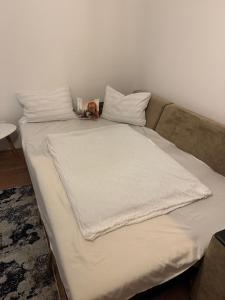 a bed with a white blanket on top of it at La Suciu in Luduş