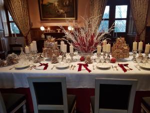 a table with a white table cloth with christmas decorations at Maison cosy citadine in Tours
