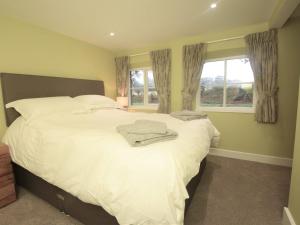 una camera da letto con un grande letto bianco con una finestra di 2 Bed in Wroxham 56104 a Hoveton