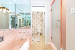 ein rosa Badezimmer mit Badewanne und Toilette in der Unterkunft Iconic 4Br Bayfront Home W Unmatched Indooroutdoor Living By Beachview Rentals in Newport Beach + 27 Fotos