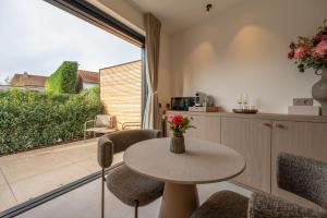 a room with a table and chairs and a balcony at Luxe Guestroom free bikes and parking in Bruges