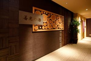 a hallway with a wall of wood logs at Dormy Inn Nagano in Nagano