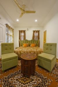 una camera da letto con un letto e due sedie di The Shesh Bagh Boutique - Garden Stay Near Dal Lake & Mughal Garden a Srinagar