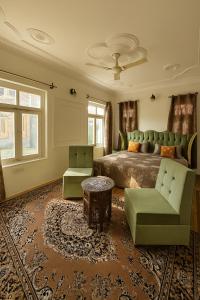 una camera da letto con un letto, due sedie e un tavolo di The Shesh Bagh Boutique - Garden Stay Near Dal Lake & Mughal Garden a Srinagar