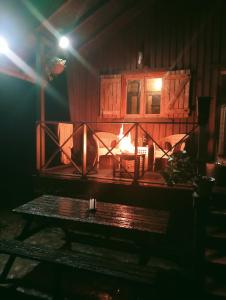 einen Kamin in einem Raum mit einer Bank davor in der Unterkunft La Cabaña del Paito in Guillena