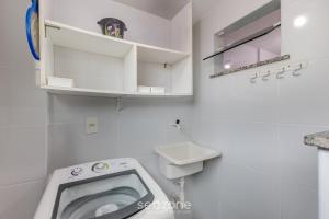 a white bathroom with a toilet and a sink at Apto 2 Quartos a 200 m da Praia MAO0203 in Cururupe