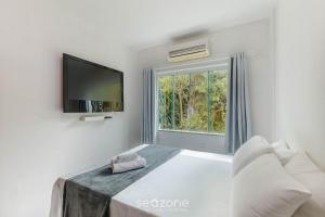 a white bedroom with a bed and a window at Apto 2 Quartos a 200 m da Praia MAO0203 in Cururupe