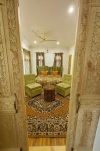 una porta aperta su un soggiorno con tavolo e sedie di The Shesh Bagh Boutique - Garden Stay Near Dal Lake & Mughal Garden a Srinagar