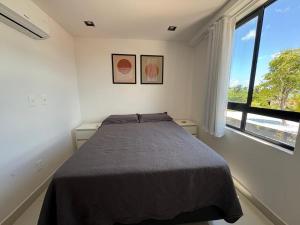 a bedroom with a bed and a large window at 105 Dutra Ocean Flat - Take Home in Tambaú +33 photos