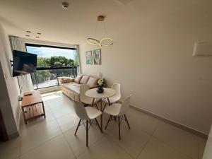 a living room with a table and chairs and a couch at 105 Dutra Ocean Flat - Take Home in Tambaú