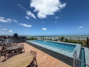 a swimming pool on a deck with a view of the ocean at 105 Dutra Ocean Flat - Take Home in Tambaú
