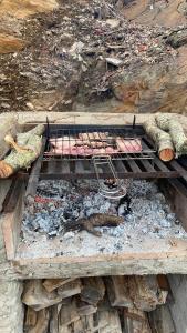 ein Grill mit Fleisch auf einem Schutthaufen in der Unterkunft La Cabaña del Paito in Guillena