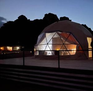 a large tent is lit up at night at Golden Gate Luxury Camp in Wadi Rum