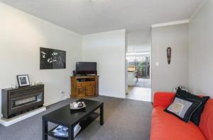un salon avec un canapé rouge et une télévision dans l'établissement Modern 2BR Apartment North Adelaide, à North Adelaide