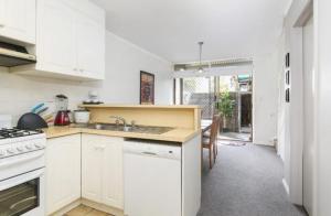 une cuisine blanche avec un évier et une cuisinière dans l'établissement Modern 2BR Apartment North Adelaide, à North Adelaide 5 autres photos