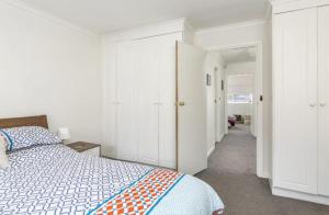 - une chambre blanche avec un lit et un couloir dans l'établissement Modern 2BR Apartment North Adelaide, à North Adelaide