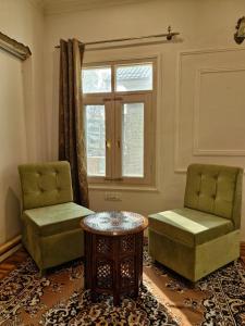 due sedie e un tavolo in una stanza con una finestra di The Shesh Bagh Boutique - Garden Stay Near Dal Lake & Mughal Garden a Srinagar 1 altra foto
