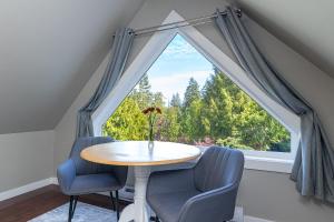 a table and two chairs in front of a large window at Shawnigan Suite B & B in Shawnigan Lake