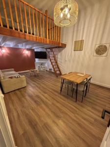 a living room with a staircase and a table at le cocon valenciennes gare in Valenciennes