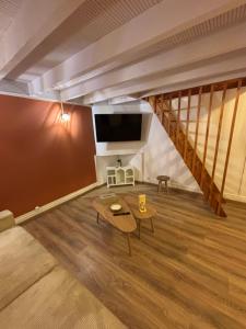 a living room with a couch and a tv at le cocon valenciennes gare in Valenciennes