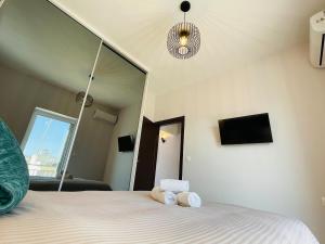 a bedroom with a bed with a mirror and a tv at Casa del Rey in Piraeus