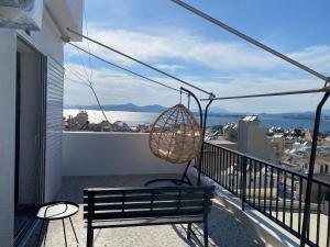 a bench on a balcony with a view of the ocean at Casa del Rey in Piraeus