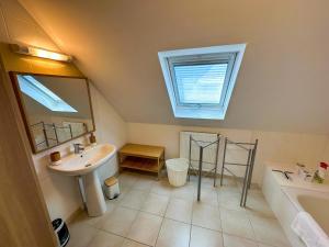 a bathroom with a sink and a mirror and a tub at KER EOZEN - Maison confortable en plein centre in Plouguerneau +32 photos