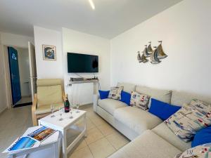 a living room with a couch and a table at KER EOZEN - Maison confortable en plein centre in Plouguerneau