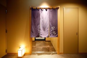 a window with a purple curtain in a room at Dormy Inn Nagano in Nagano