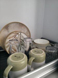 弗利康弗拉克Sea'Amore - Luxury Premium Beach Apartment的架子上放着一个托盘，托盘里有两个杯子和其他一些盘子。