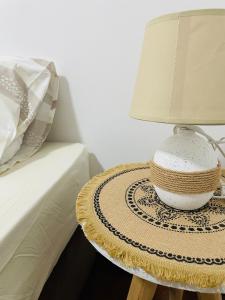 une lampe sur une table à côté d'un lit dans l'établissement Lovely bedroom in a centrally located apartment, à Maputo