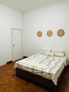- une chambre avec un grand lit aux murs blancs dans l'établissement Lovely bedroom in a centrally located apartment, à Maputo