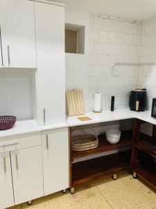 une cuisine avec des placards blancs et un comptoir dans l'établissement Lovely bedroom in a centrally located apartment, à Maputo