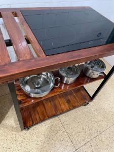 une table en bois avec des casseroles et des poêles sur une étagère dans l'établissement Lovely bedroom in a centrally located apartment, à Maputo