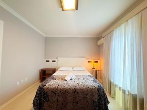 a bedroom with a bed and a large window at Casa moderna e extremamente confortável - R1552 in Balneário Camboriú