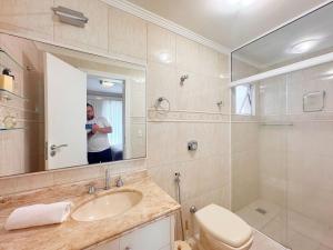 a man taking a picture of a bathroom at Casa moderna e extremamente confortável - R1552 in Balneário Camboriú +41 photos