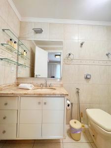 a bathroom with a sink and a toilet and a mirror at Casa moderna e extremamente confortável - R1552 in Balneário Camboriú