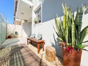 a patio with a bench and a potted plant at Casa moderna e extremamente confortável - R1552 in Balneário Camboriú