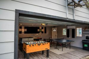 a garage with a ping pong table and a ping pong table at Cottage at Cast Away Kayaks Fire Pit & Game Room in Teall Beach