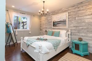 a bedroom with a white bed and a wooden wall at Shawnigan Suite B & B in Shawnigan Lake