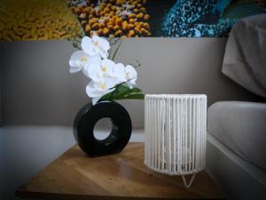 un vase noir avec des fleurs blanches sur une table dans l'établissement Apartmány Hradební 16, à České Budějovice 6 autres photos