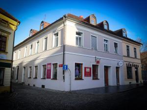 a white building with red signs on the side of it at Apartmány Hradební 16 in České Budějovice