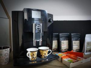 une cafetière avec deux tasses à café sur un plateau dans l'établissement Apartmány Hradební 16, à České Budějovice