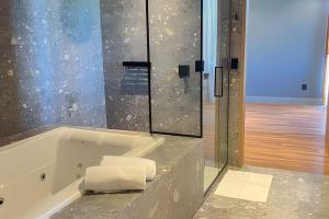 ein Badezimmer mit einer Badewanne und Handtüchern auf der Theke in der Unterkunft Apartamento com banheira Dupla Vale dos Vinhedos in Garibaldi + 21 Fotos