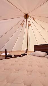 una tienda de campaña grande con dos sillas y una cama en Majicdunes, en Al Raka