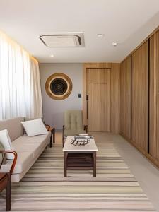 ein Wohnzimmer mit Sofa und Tisch in der Unterkunft Apartamento com banheira Dupla Vale dos Vinhedos in Garibaldi