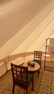 una habitación con dos camas y una mesa y sillas en Majicdunes, en Al Raka