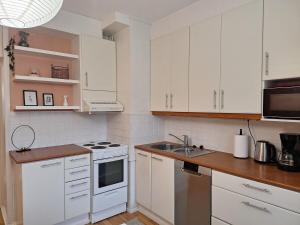 Una cocina con gabinetes blancos y un fregadero. en Ihana kaksio lähellä luontoa!, en Tampere